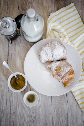 Italian cornettos with powdered sugar on plate, French press stock photo