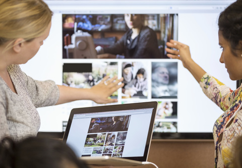 Female photo editors discussing in office stock photo