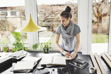 Architektin bei der Arbeit am Tisch im Heimbüro - MASF05083