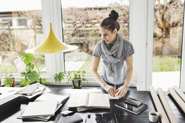 Female architect working at table in home office - MASF05083