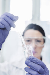 Female scientist examining chemical in laboratory - MASF05087