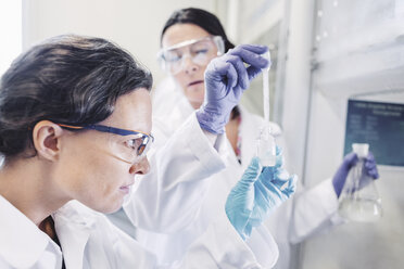 Female scientists examining chemical in laboratory - MASF05116