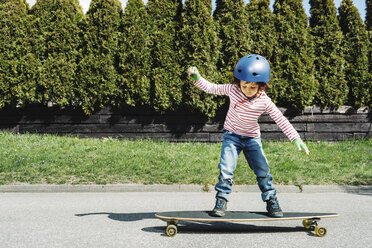 Junge in voller Länge auf Skateboard im Hof balancierend - MASF05122