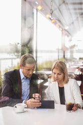 Business people using digital tablet in cafe - MASF05142