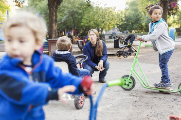 Verärgerter Lehrer mit spielenden Kindern auf dem Spielplatz - MASF05154