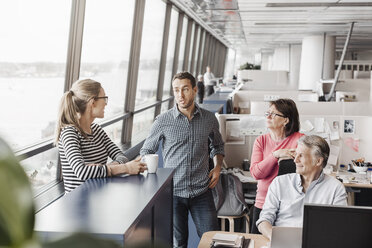 Business people discussing at cubicle in office - MASF05176