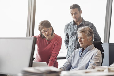 Business people using laptop at desk in office - MASF05177