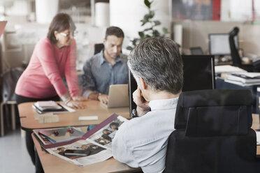 Geschäftskollegen bei der Arbeit am Schreibtisch im Büro - MASF05178