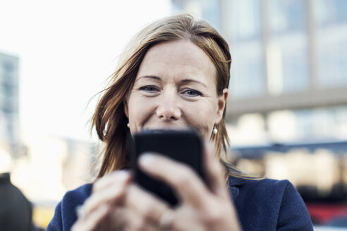 Geschäftsfrau benutzt Mobiltelefon im Freien - MASF05203