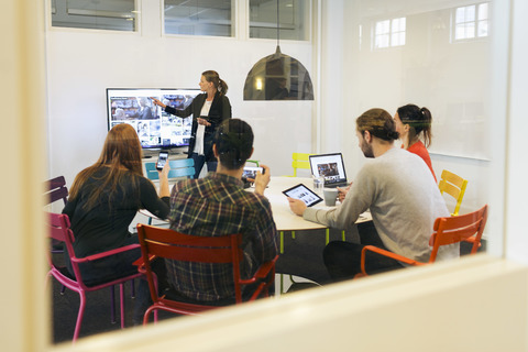 Businesswoman giving presentation during conference call in board room of creative office stock photo