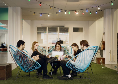 Kreative Geschäftsleute nutzen Technologien in der Bürokantine, lizenzfreies Stockfoto