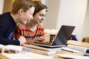 Schoolboys using laptop together in classroom - MASF05279