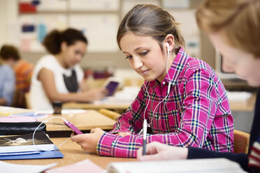 Schülerin hört Musik über ihr Smartphone im Klassenzimmer - MASF05281