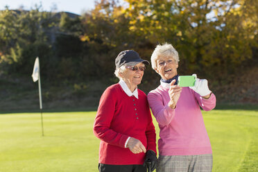 Ältere Golferinnen beim Fotografieren auf dem Golfplatz - MASF05293