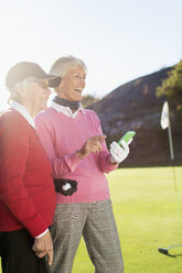 Ältere Golferinnen lächeln auf dem Golfplatz - MASF05294