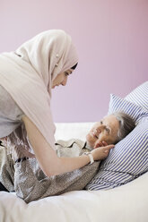 Junge Hauspflegerin, die einer älteren Frau im Bett hilft - MASF05318