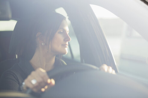Junge Geschäftsfrau schaut beim Autofahren durch das Fenster - MASF05351