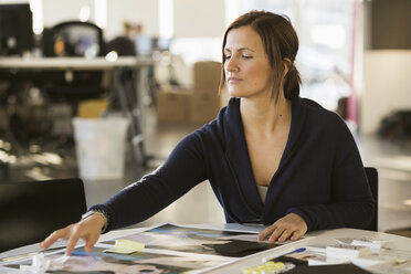 Young businesswoman working on photographs in office - MASF05352