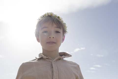 Porträt eines Jungen mit Blumen im Gegenlicht, lizenzfreies Stockfoto