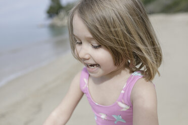 Porträt eines glücklichen kleinen Mädchens, das am Strand spielt - KMKF00183