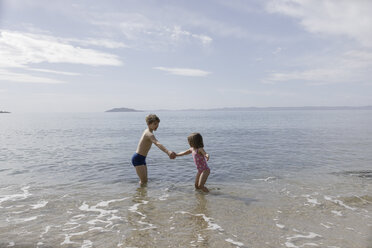 Bruder und kleine Schwester spielen zusammen an der Strandpromenade - KMKF00185