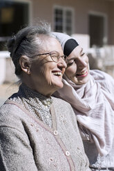 Lächelnde ältere Frau und weibliche Hauspflegerin vor dem Haus - MASF05360