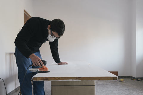 Man sanding door stock photo