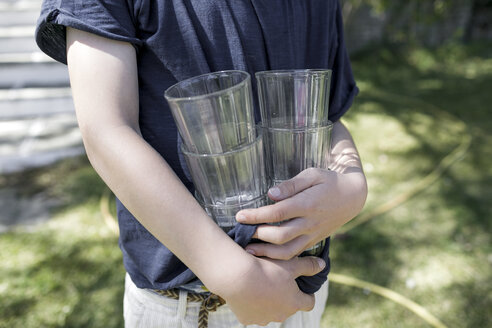 Junge steht im Garten und hält leere Gläser, Teilansicht - KMKF00191