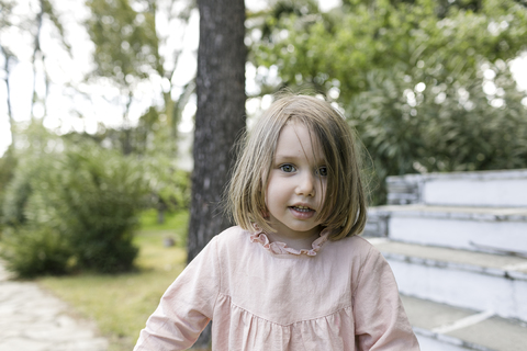 Porträt eines kleinen Mädchens im Garten, lizenzfreies Stockfoto