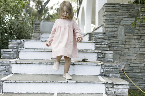 Kleines Mädchen geht die Treppe hinunter, lizenzfreies Stockfoto