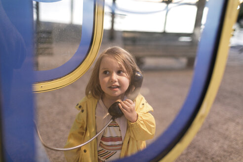 Porträt eines kleinen Mädchens in einer Telefonzelle - KMKF00203
