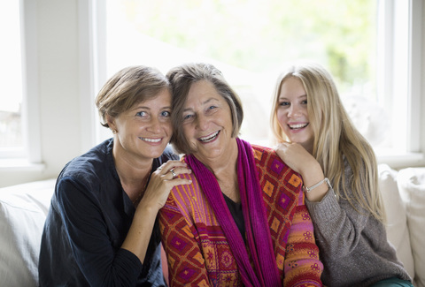 Porträt einer glücklichen Frau der dritten Generation im Wohnzimmer, lizenzfreies Stockfoto