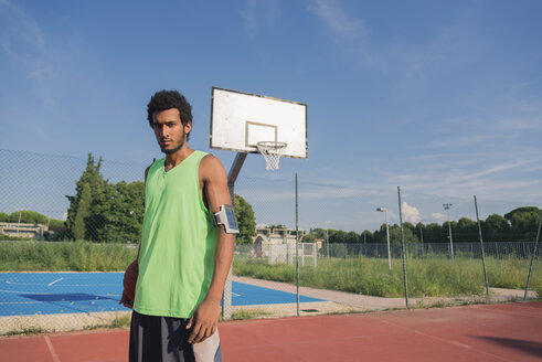 Junger Basketballspieler mit Ball und Armtasche - FMOF00339