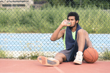 Young basketball player drinking from water bottle - FMOF00355