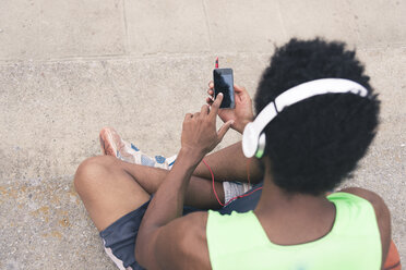 Basketballspieler hört Musik, Smartphone und Kopfhörer - FMOF00356