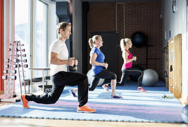 Menschen trainieren mit Kettlebells im Fitnessstudio - MASF05537