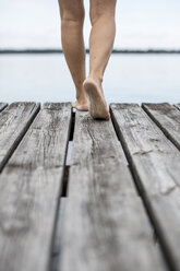 Low section of woman walking on pier - MASF05556