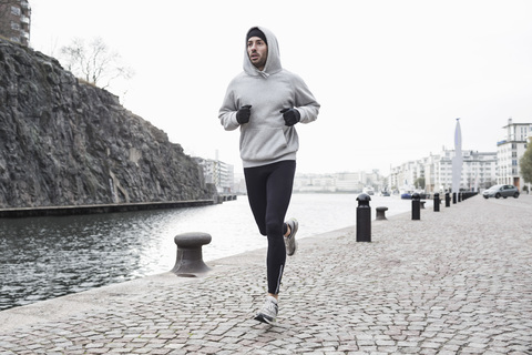 Mann joggt am Kanalufer, lizenzfreies Stockfoto