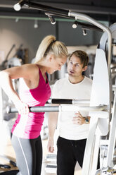 Trainer motiviert Kunden beim Training im Fitnessstudio - MASF05563