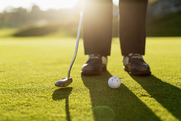 Low section of senior woman putting green on golf course - MASF05567