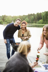 Glückliche Freunde bei einer Grillparty am Pier - MASF05578