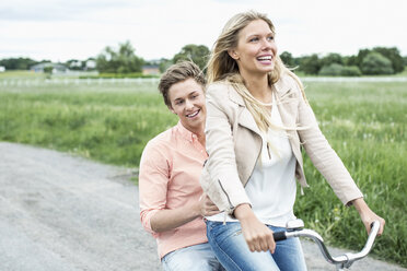 Happy young couple enjoying bicycle ride at countryside - MASF05591