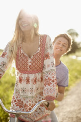 Happy young couple enjoying bicycle ride at countryside - MASF05594