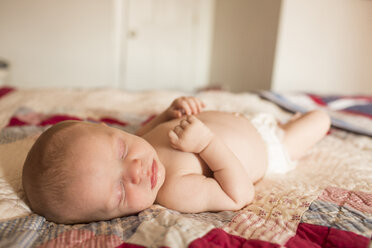 Shirtless baby boy sleeping on bed at home - CAVF43011