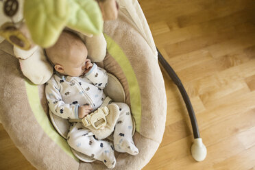 High angle view of baby boy sucking thumb while sleeping in bassinet at home - CAVF43015