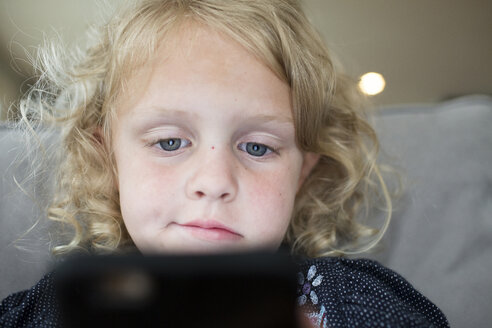 Niedriger Blickwinkel von Mädchen mit Tablet-Computer auf dem Bett zu Hause - CAVF43057