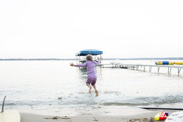 Rückansicht eines am Strand springenden Mädchens bei klarem Himmel - CAVF43081