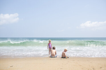 Siblings playing at beach against sky during sunny day - CAVF43086