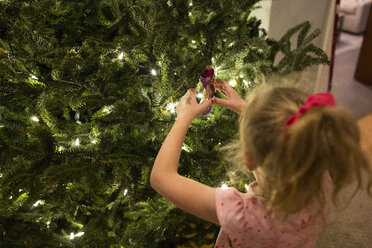 Hohe Winkel Ansicht des Mädchens stehend durch Weihnachtsbaum zu Hause - CAVF43102