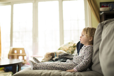 Girl looking away while relaxing on sofa at home - CAVF43105